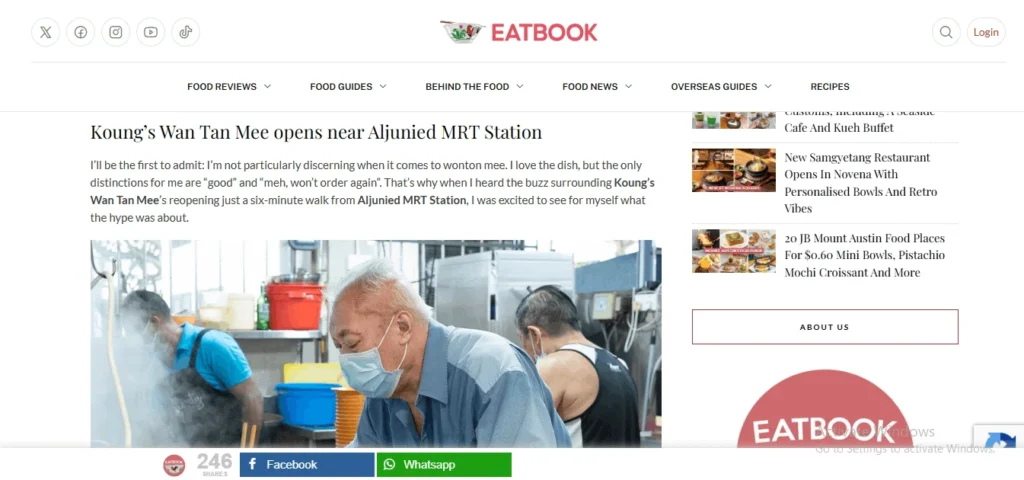 Screenshot of the Eatbook website featuring an article titled "Koung's Wan Tan Mee opens near Aljunied MRT Station." The article's featured photograph shows an older hawker stall owner wearing a blue shirt and a light blue surgical mask, looking downward in a busy commercial kitchen. In the background, two other staff members are working amidst rising steam and kitchen equipment.