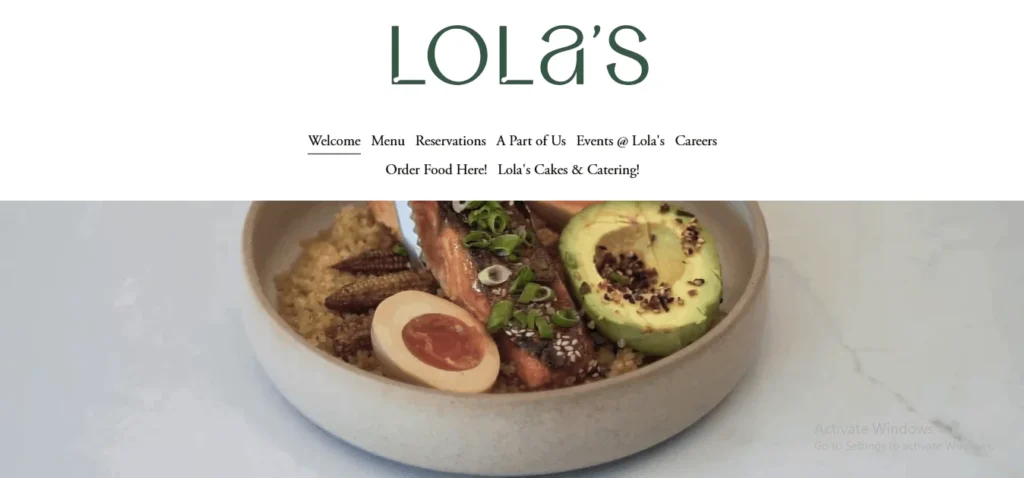 "Website header for Lola's cafe, featuring the dark green 'Lola's' logo, navigation menu links, and a banner image of a grain bowl with grilled salmon, avocado, and a soft-boiled egg."
