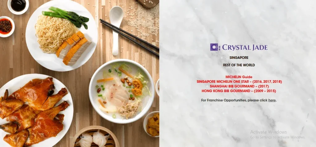 A promotional banner for Crystal Jade restaurant split into two sections. The left side features a top-down view of several Chinese dishes on a light wooden table, including roasted pork belly with noodles and greens, a bowl of fish congee, roasted duck, and a bamboo dim sum steamer. The right side features a white marble background with the Crystal Jade logo and text highlighting their Michelin Guide accolades, including a Singapore Michelin One Star (2016–2018), Shanghai Bib Gourmand (2017), and Hong Kong Bib Gourmand (2009–2015).