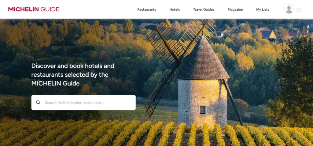 "Screenshot of the Michelin Guide website with a scenic image of a French stone windmill in a vineyard during autumn."