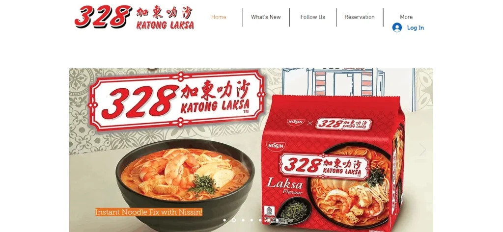 A website screenshot for 328 Katong Laksa showing the site header with navigation links and a promotional banner featuring a bowl of Katong laksa and a red Nissin 328 Katong Laksa instant noodle package.