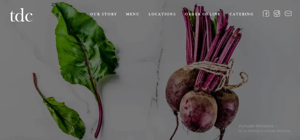 TDC website homepage header featuring fresh whole red beetroots tied with string and green beet leaves against a light marble surface.