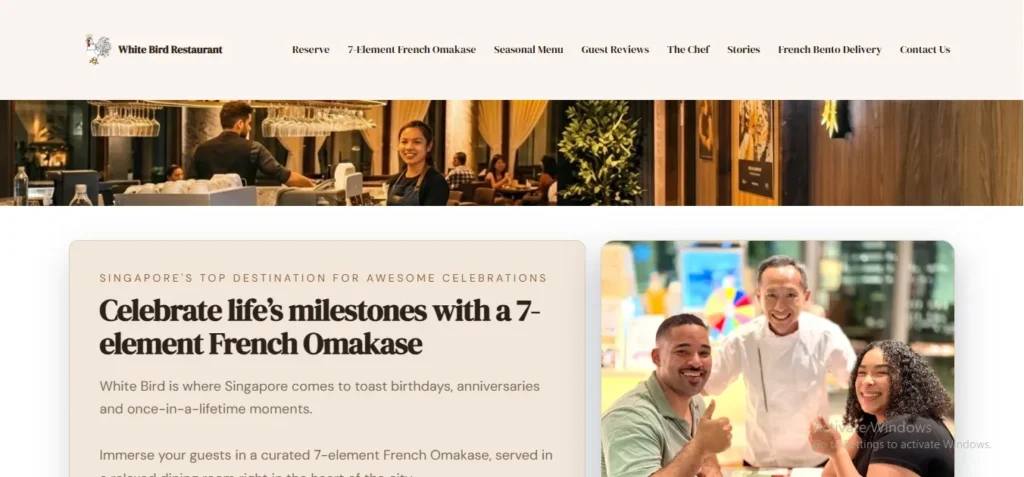 A screenshot of the homepage for "White Bird Restaurant," featuring a navigation bar with options like "7-Element French Omakase" and "French Bento Delivery." Below a panoramic banner image of the warm, modern restaurant interior and staff, a section reads, "Celebrate life's milestones with a 7-element French Omakase," alongside a photo of smiling guests with a chef in a white uniform giving a thumbs-up.