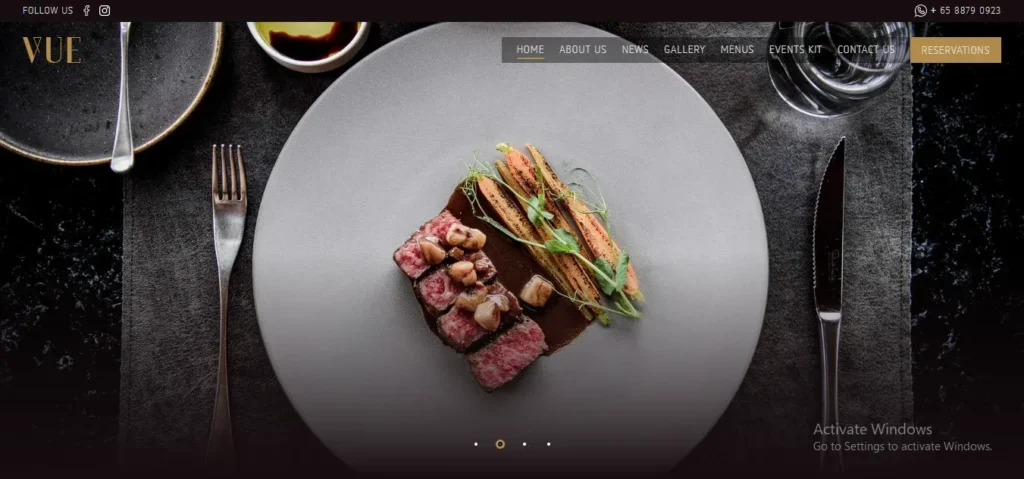 Screenshot of the website landing page for VUE restaurant, featuring an overhead shot of an artfully plated dish with sliced medium-rare beef steak and roasted baby carrots on a large grey round plate, set on a dark placemat with cutlery and a glass of water.
