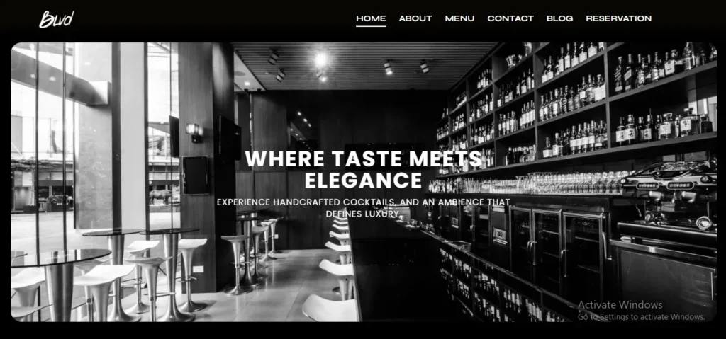 Black-and-white website banner for BLVD showing an elegant, modern bar interior with high-top seating near floor-to-ceiling windows and extensive shelves fully stocked with liquor bottles.