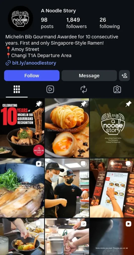 creenshot of the Instagram profile page for A Noodle Story. The bio describes the restaurant as a "Michelin Bib Gourmand Awardee for 10 consecutive years" and the "First and only Singapore-Style Ramen!" with locations listed at Amoy Street and Changi T1A Departure Area. The photo grid below displays nine posts featuring a 10-year Michelin recognition graphic, close-up shots of their signature ramen bowls, crispy potato-wrapped prawns, soft-boiled eggs, kitchen staff preparing meals, and a customer using a self-ordering kiosk.